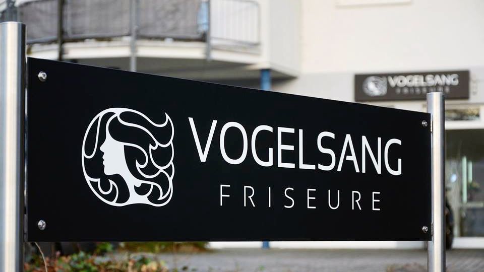 Ein schwarzes Schild mit der Aufschrift Vogelsang Frisöre
