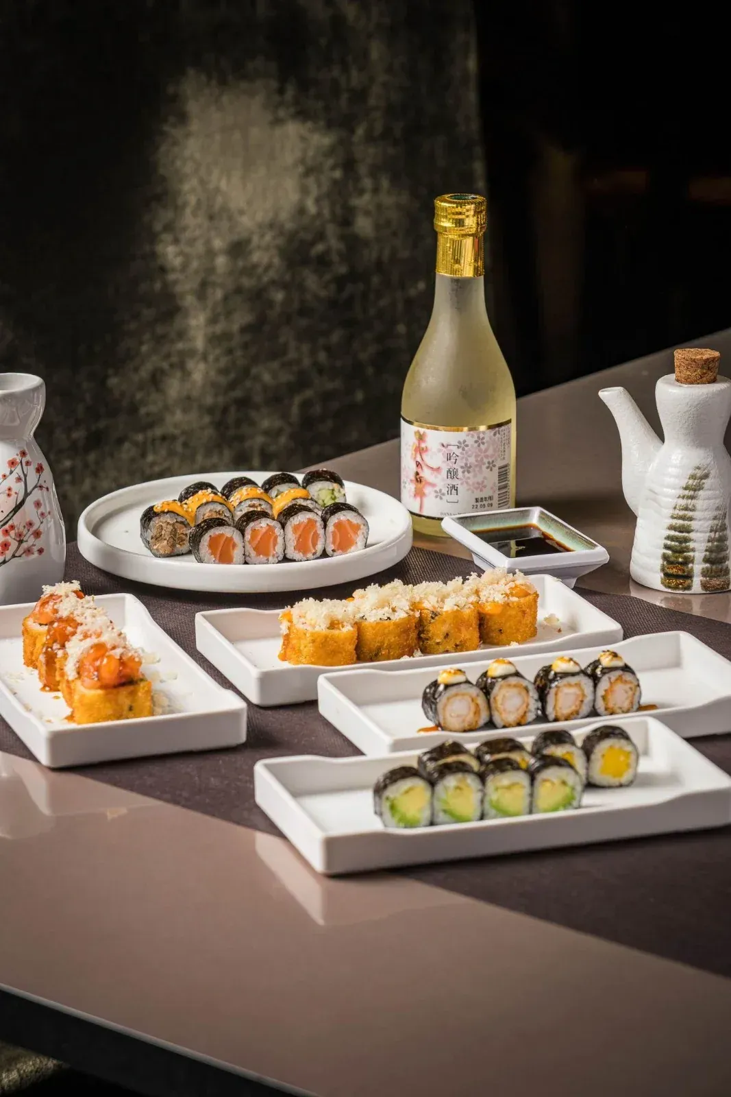 Plato de mariscos con salmón, camarones, ostras, limón y salsa de soja.