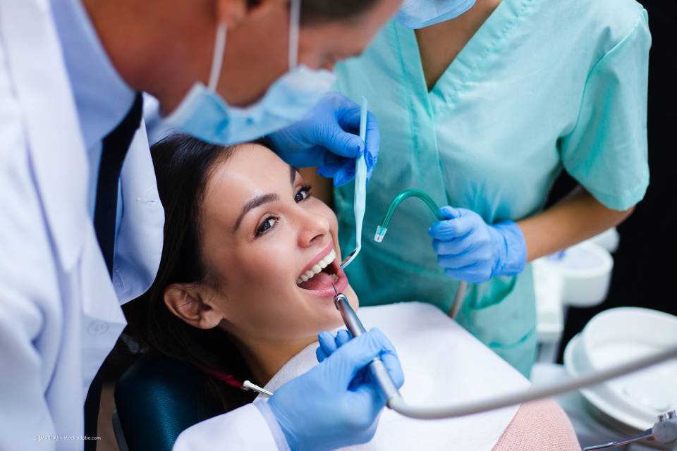 Frau bekommt die Zähne beim Zahnarzt poliert