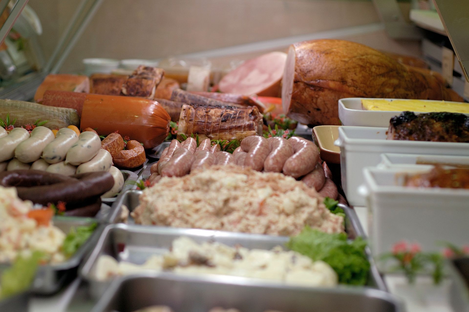 Assortiment de plats préparés et de salades présentés dans des plateaux métalliques au comptoir du buffet