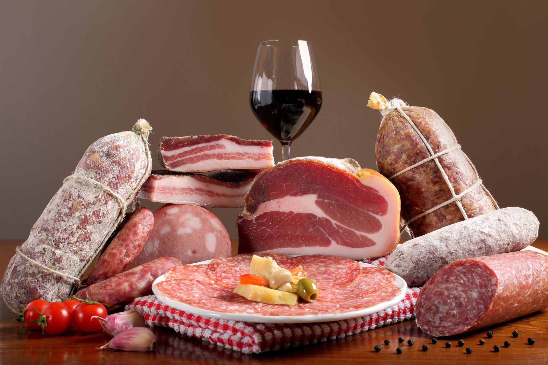 Assortiment de charcuterie et de saucisses avec du vin rouge et des tomates sur une table