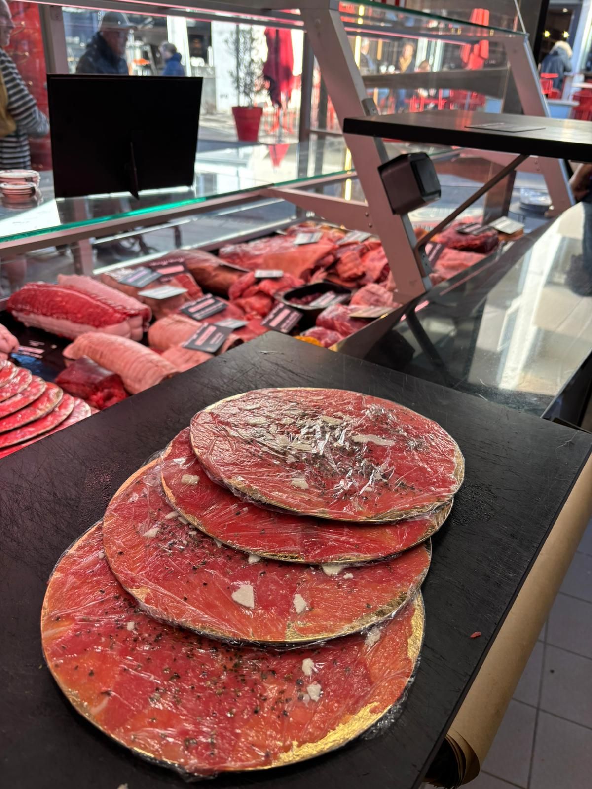 Pile de tortillas rouges ou de pains plats sur un plateau noir à l'étalage d'un marché