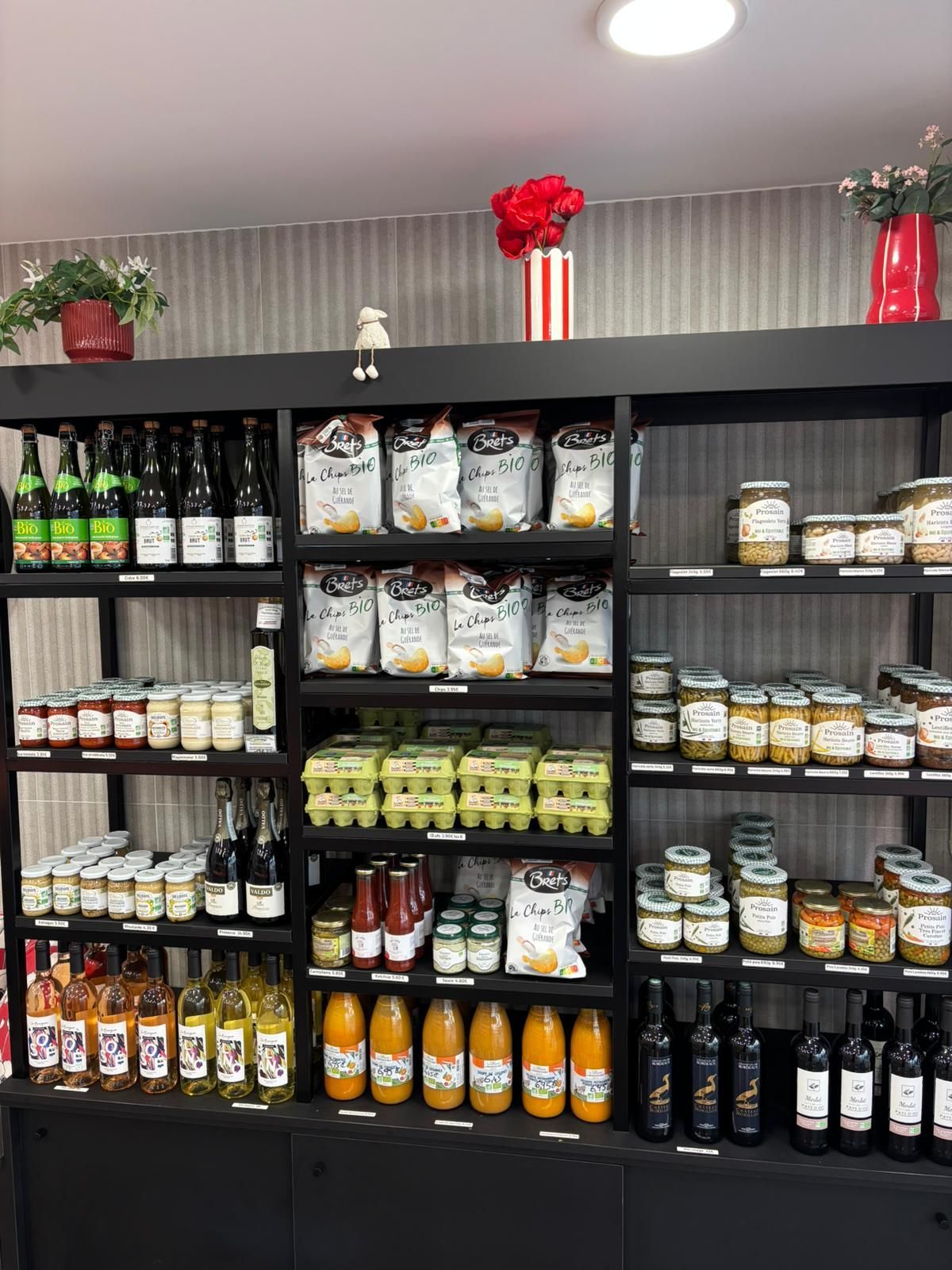 Rayon du magasin garni d'aliments en bouteille et emballés assortis, décoré de touches de rouge festives.