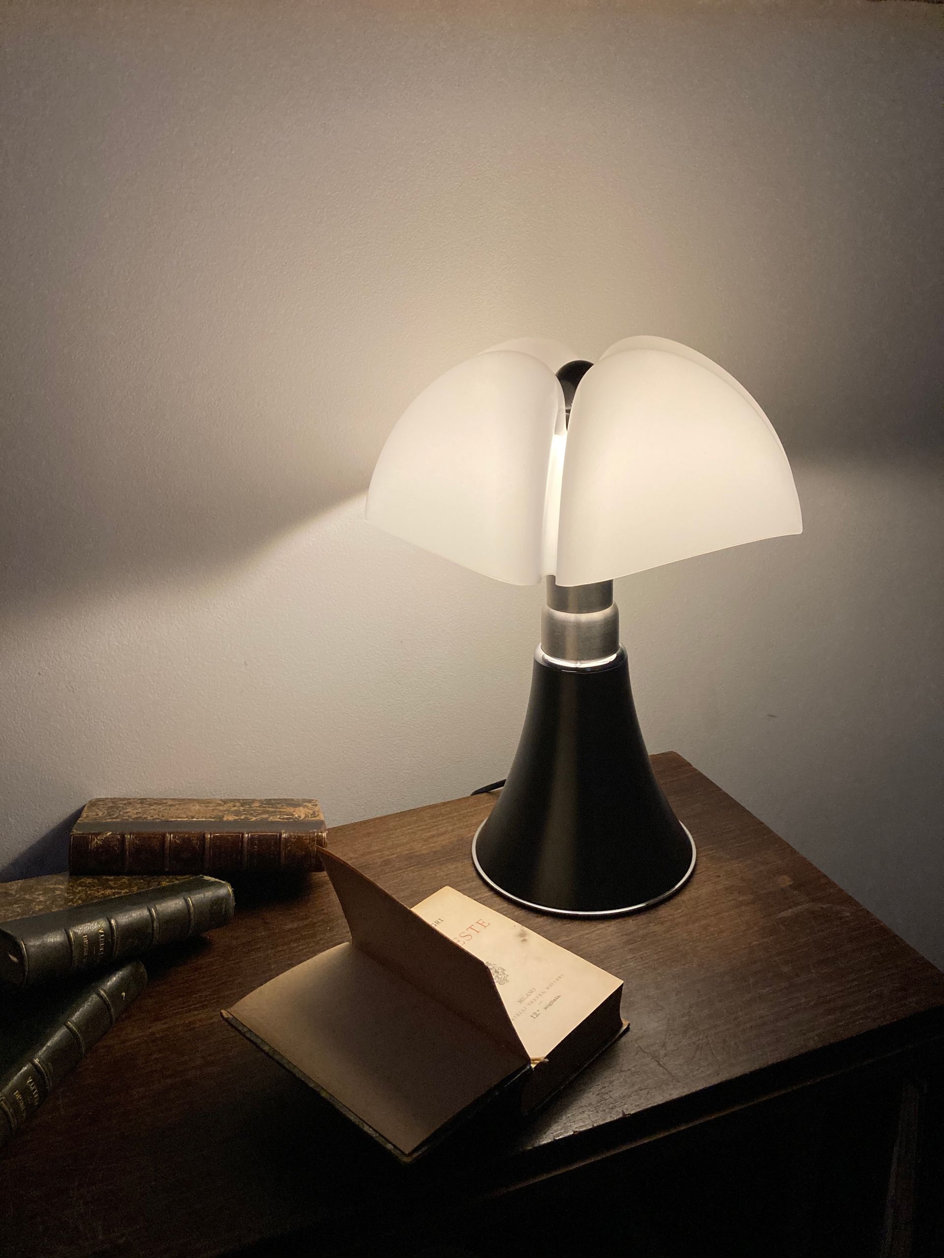 Des livres sur un vieux meuble en bois et une lampe allumée dessus