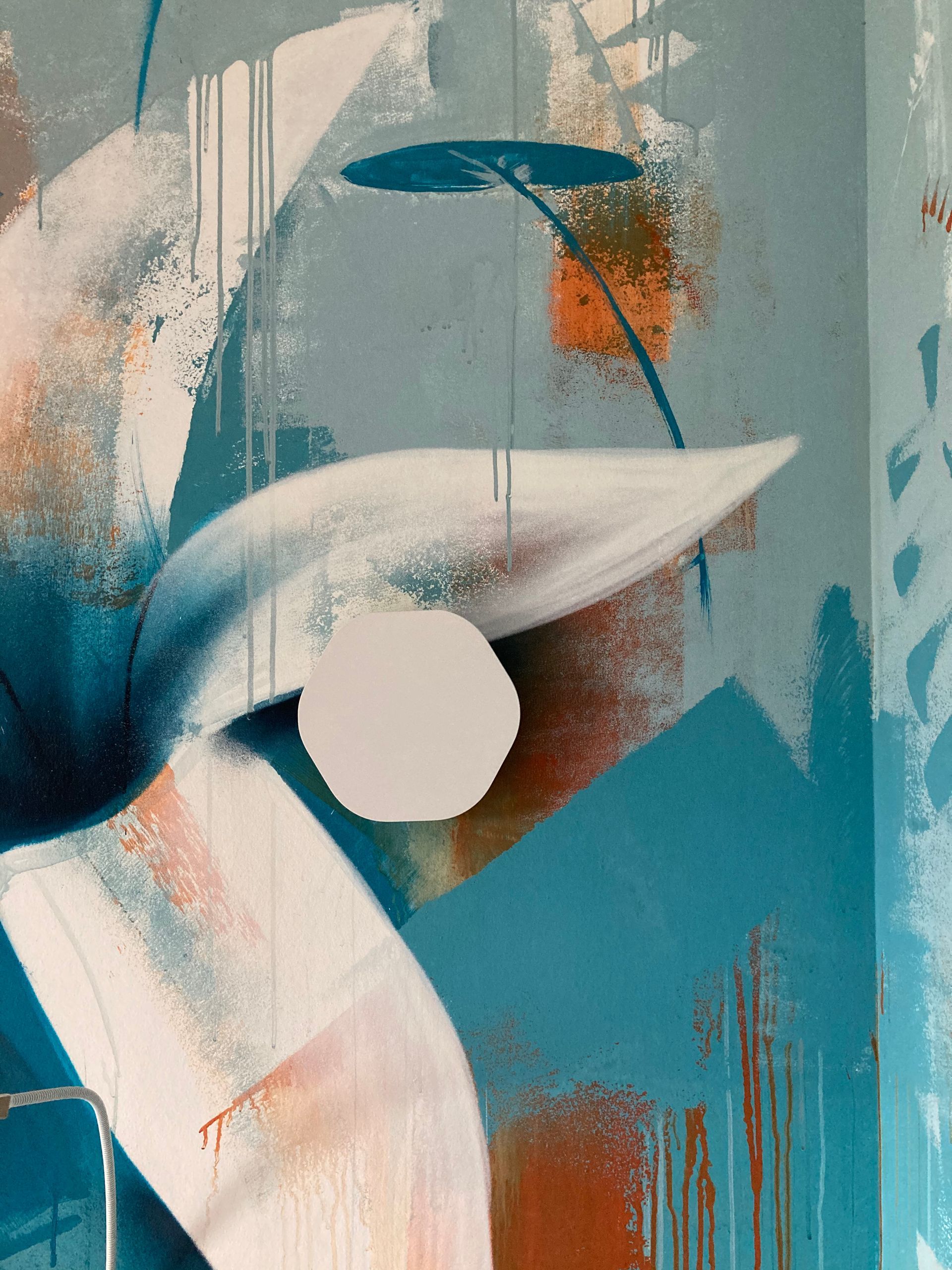 Grosse fleur peinte sur un mur avec une applique éteinte à côté