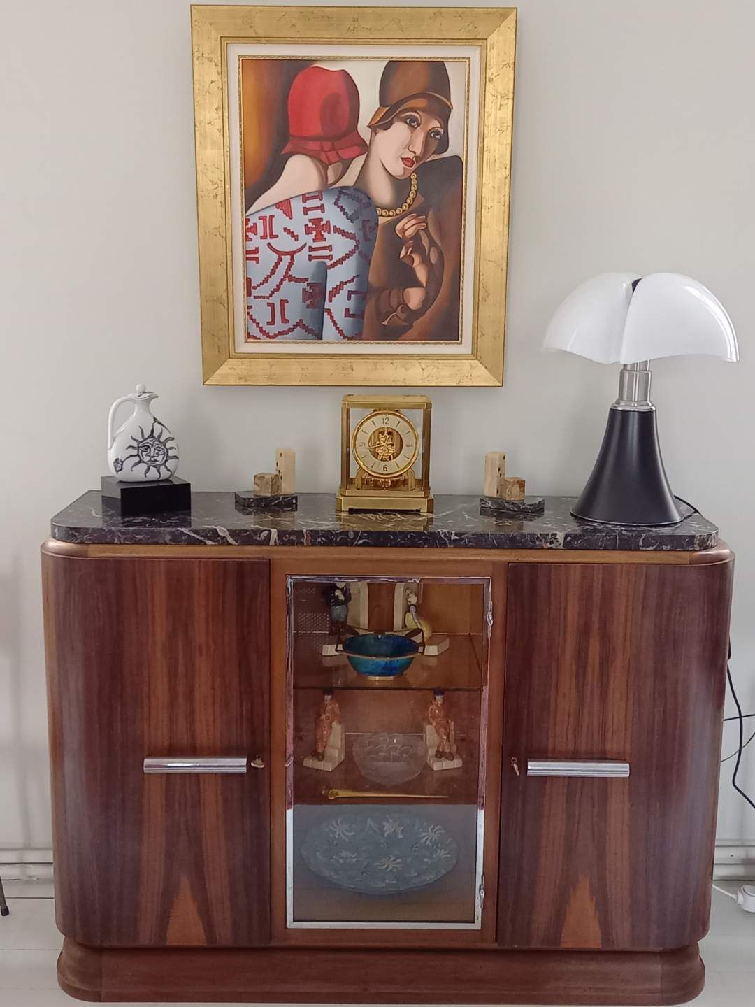 Vieux meuble en bois avec un dessus en marbre et de nombreux objets de décoration dessus