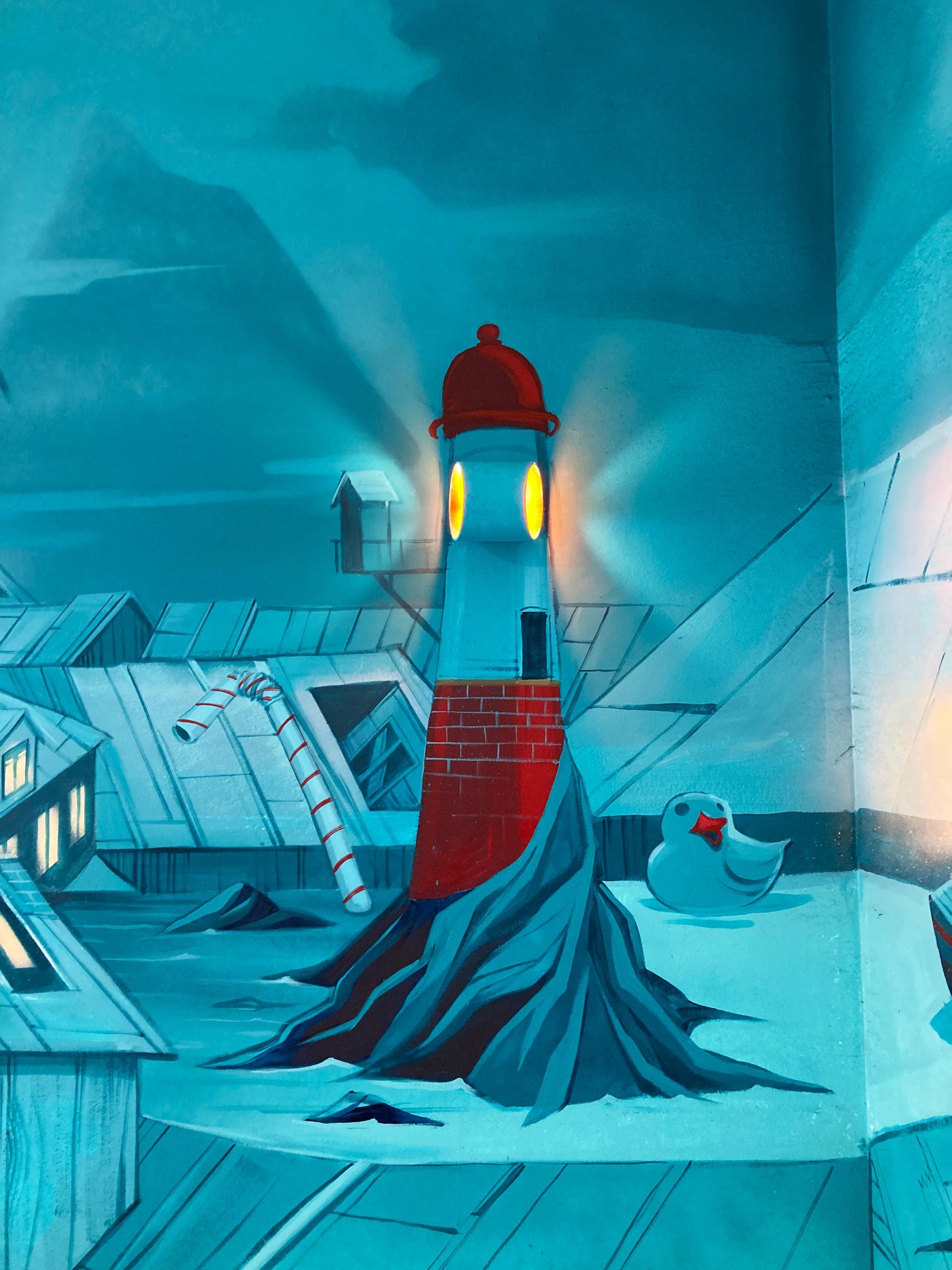 Phare peint sur un mur avec une applique allumée pour représenter la lumière du phare