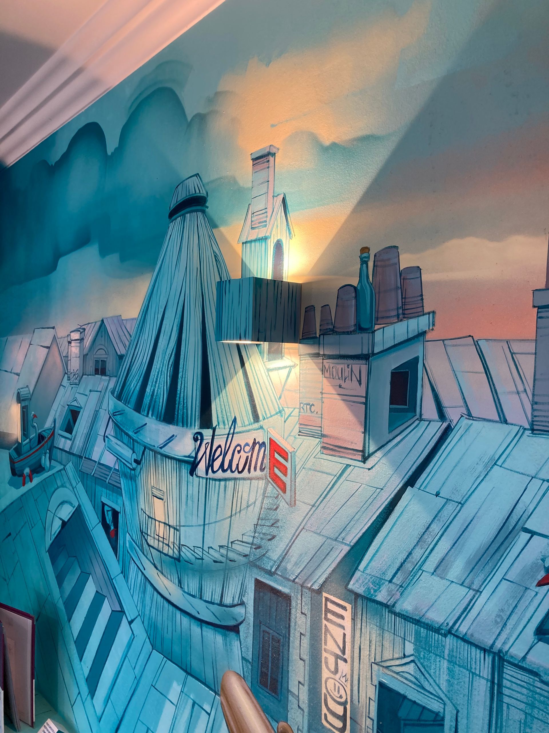 Fresque où il est écrit Welcome éclairé par une applique