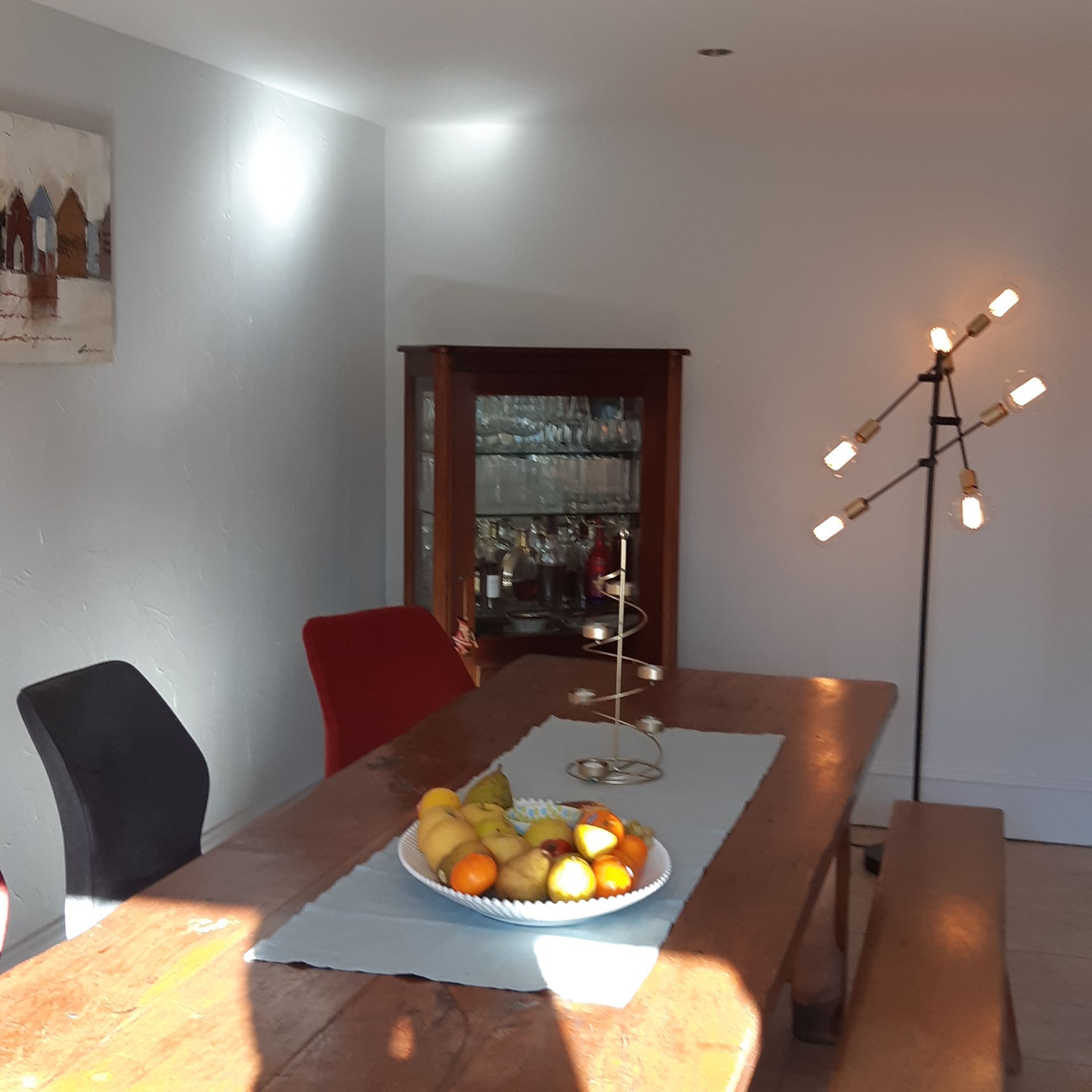 Chaises autour d'une table de salle à manger ayant une corbeille de fruit dessus