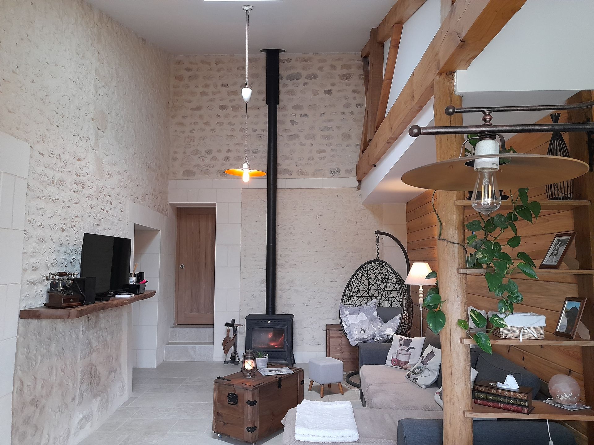 Salon tout en pierres apparentes avec un poêle à bois