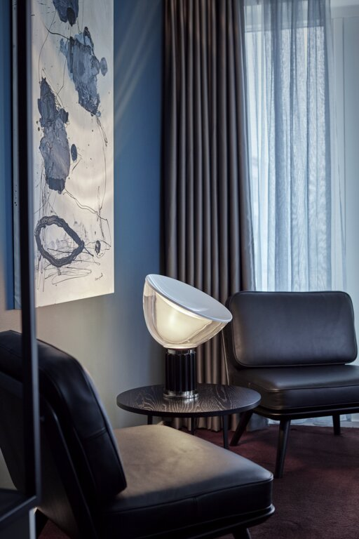 Lampe à côté d'un fauteuil en cuir noir