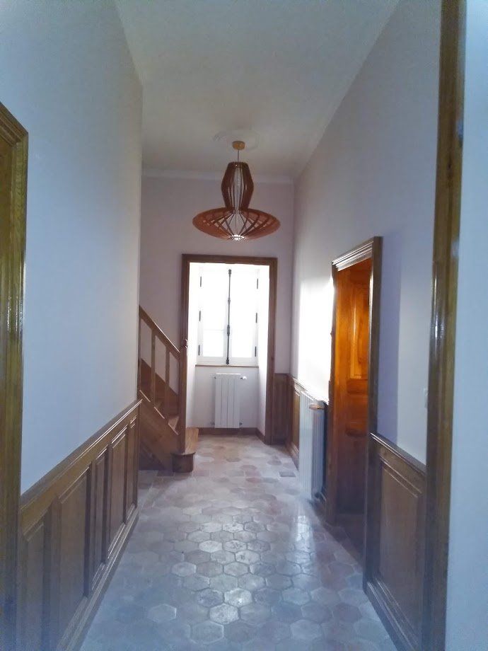 Hall d'entrée donnant sur des escaliers et deux portes