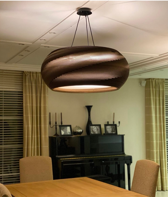 Un meuble au fond d'une pièce éclairée par un grand plafonnier