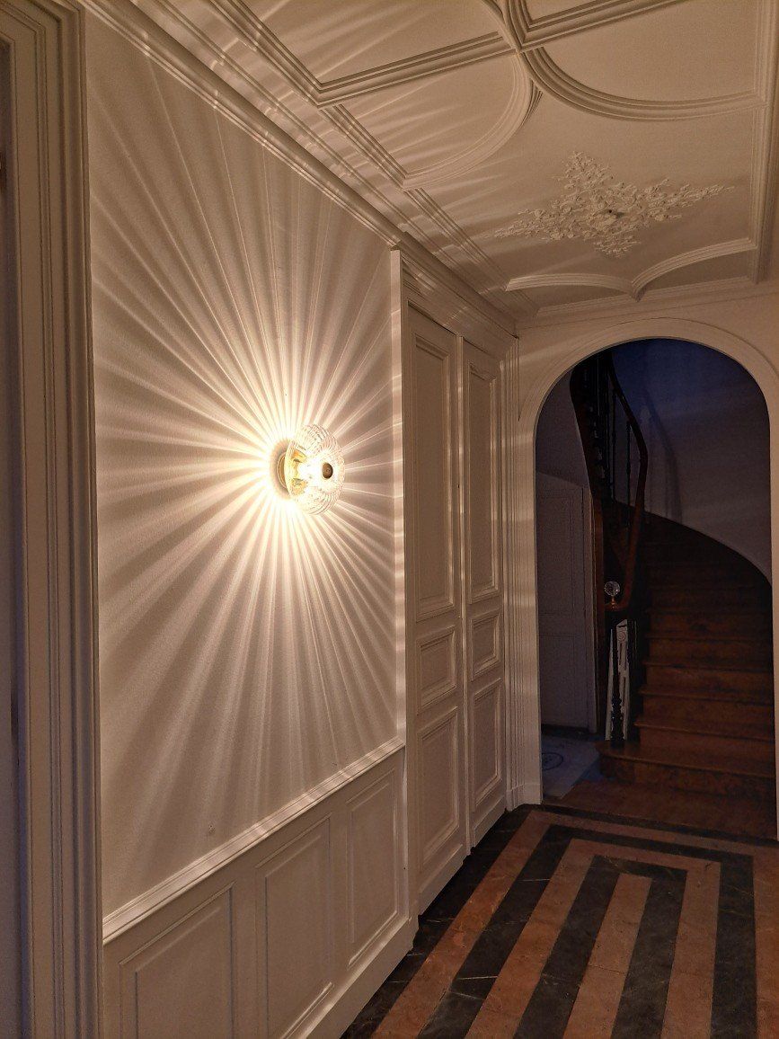 Applique murale allumée donnant l'impression qu'un soleil est peint