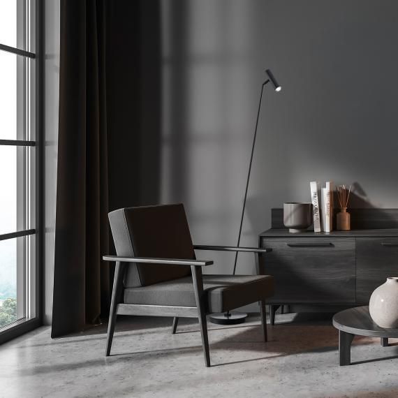 Pièce entièrement noire avec un lampadaire très fin