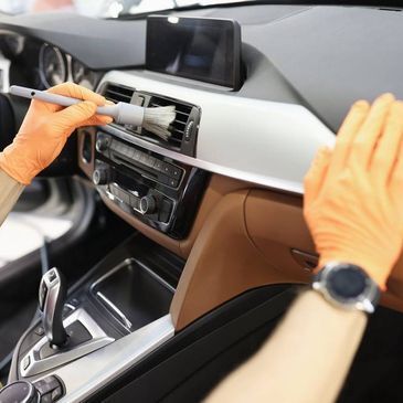 Person reinigt Innenleben eines Autos