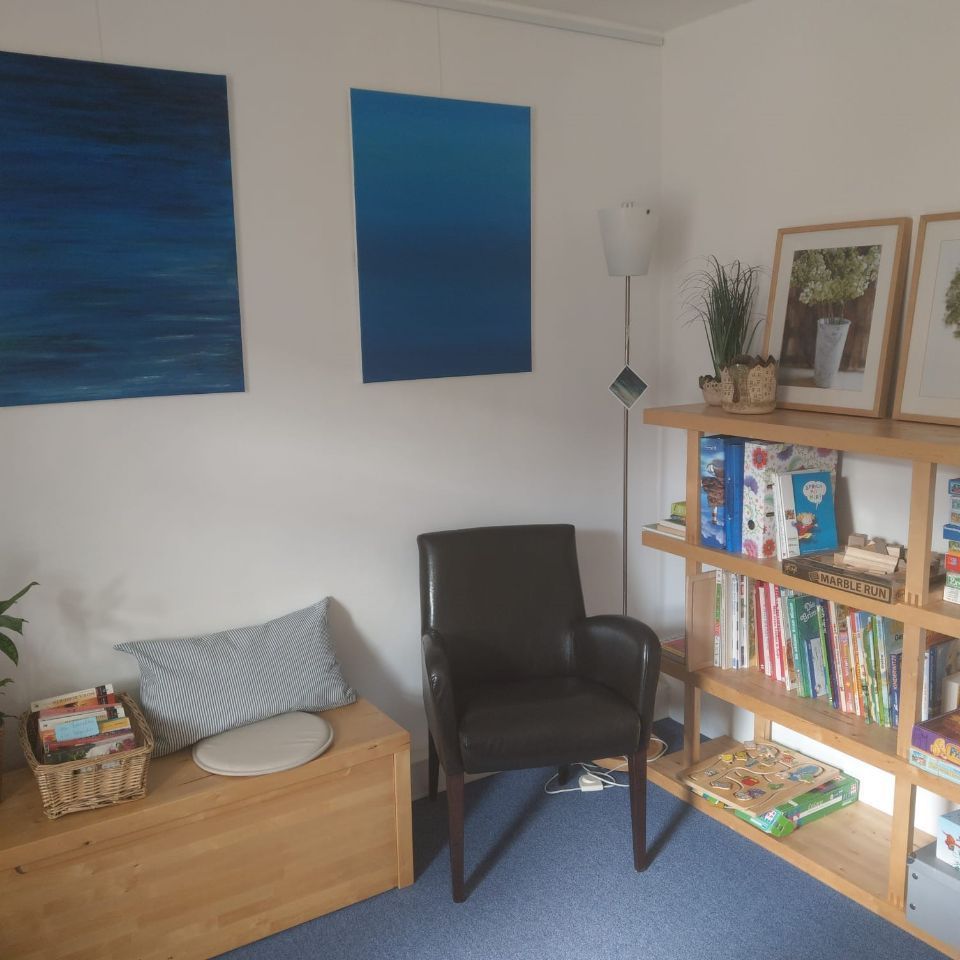 Praxis für Logopädie und klinische Lerntherapie Praxisraum mit Sessel und Regal