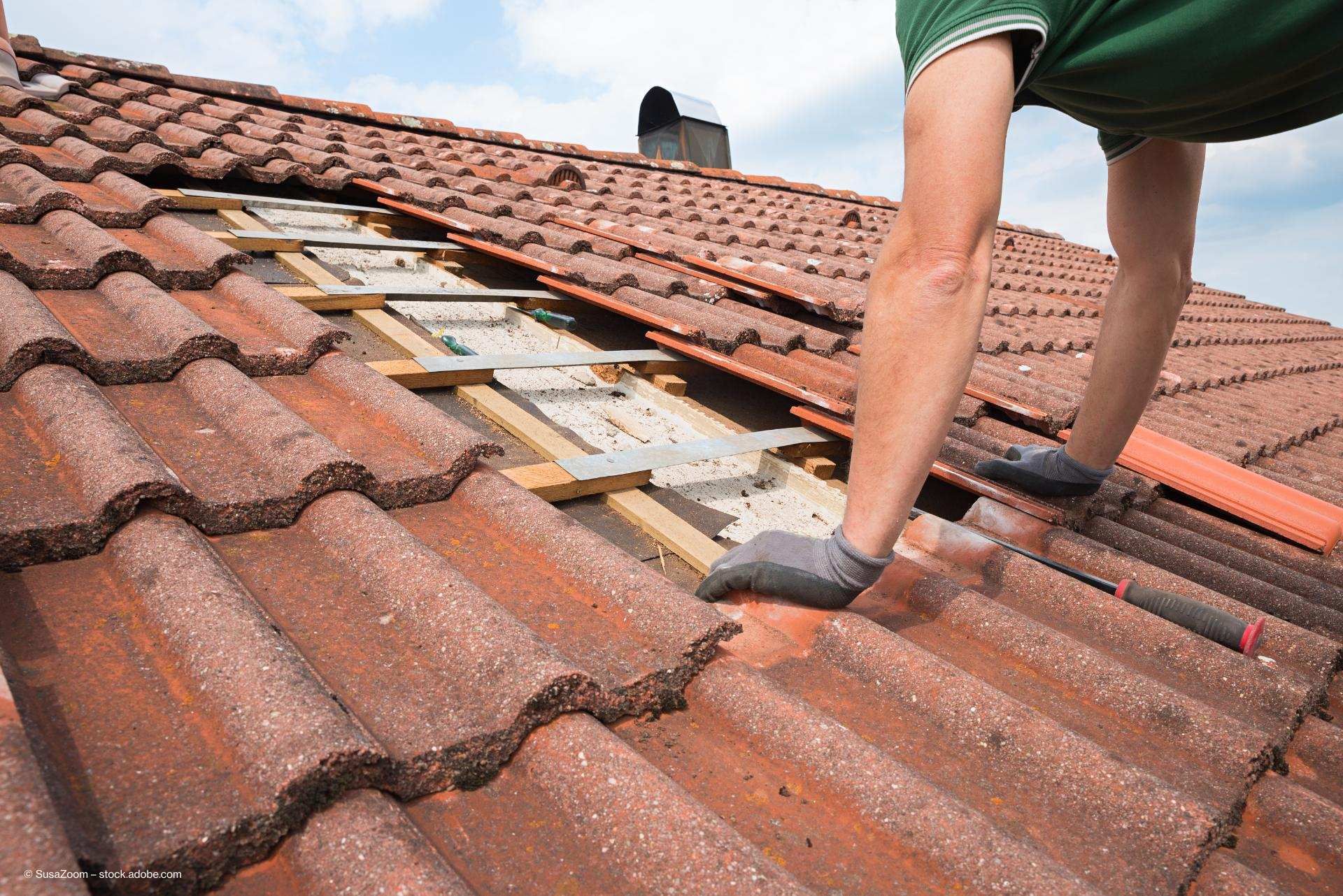 Ein Dachdecker deckt das Dach