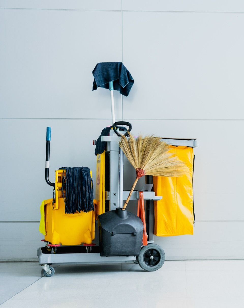 Ein Reinigungswagen mit Wischmopp und Besen