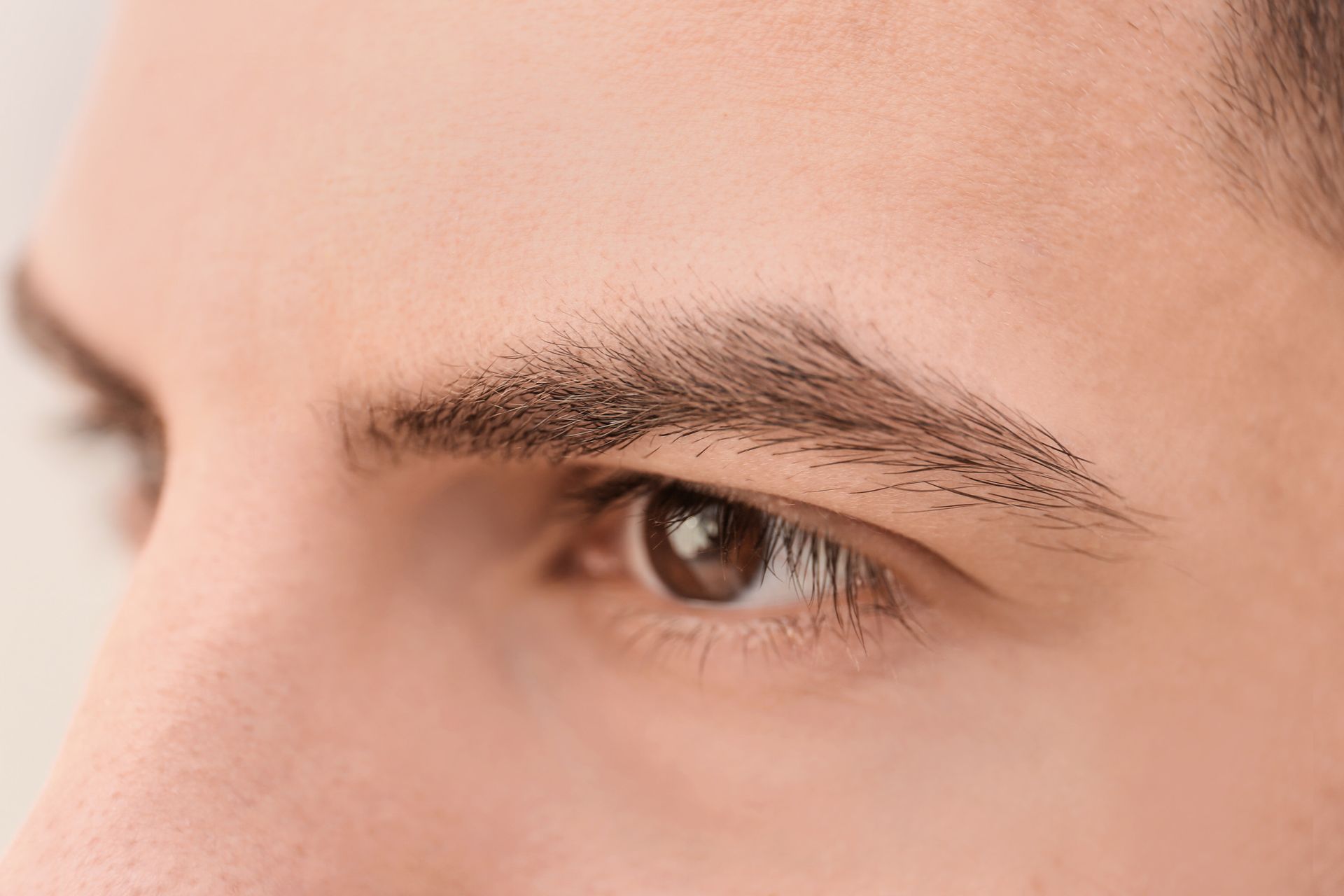 Un primer plano del ojo y las cejas de un hombre.