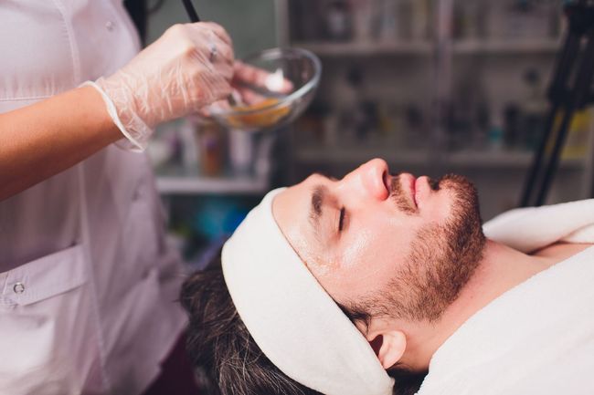 Un hombre está recibiendo un tratamiento facial en un salón de belleza.