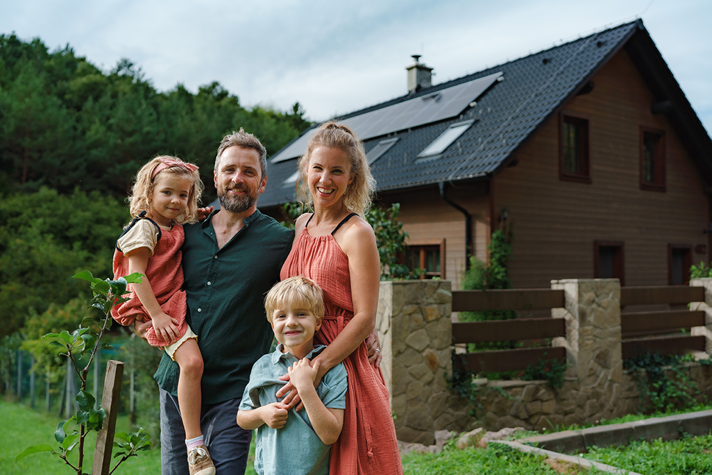 Famille devant une maison avec des panneaux solaires