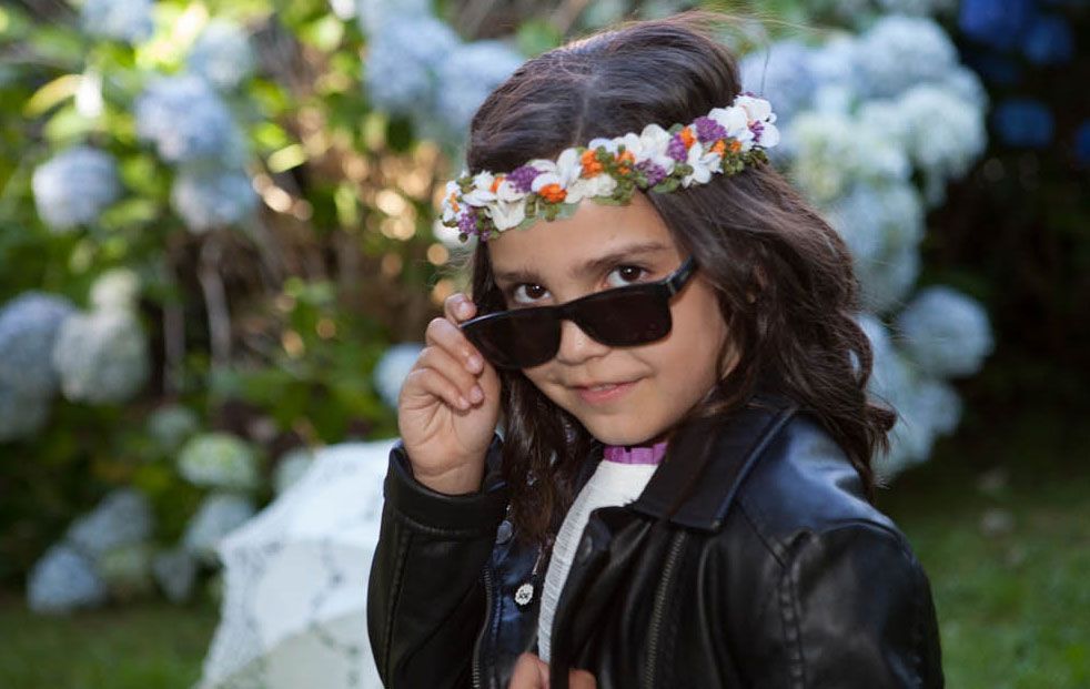 Una niña que lleva gafas de sol y una corona de flores.