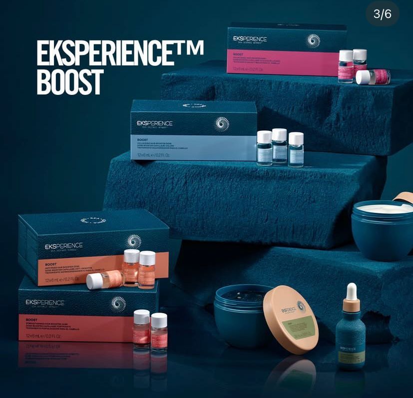 Des boîtes de produits de soin pour la peau, contenant des flacons et des pots, sont disposées sur des marches recouvertes de serviettes bleues, sur un fond bleu foncé.