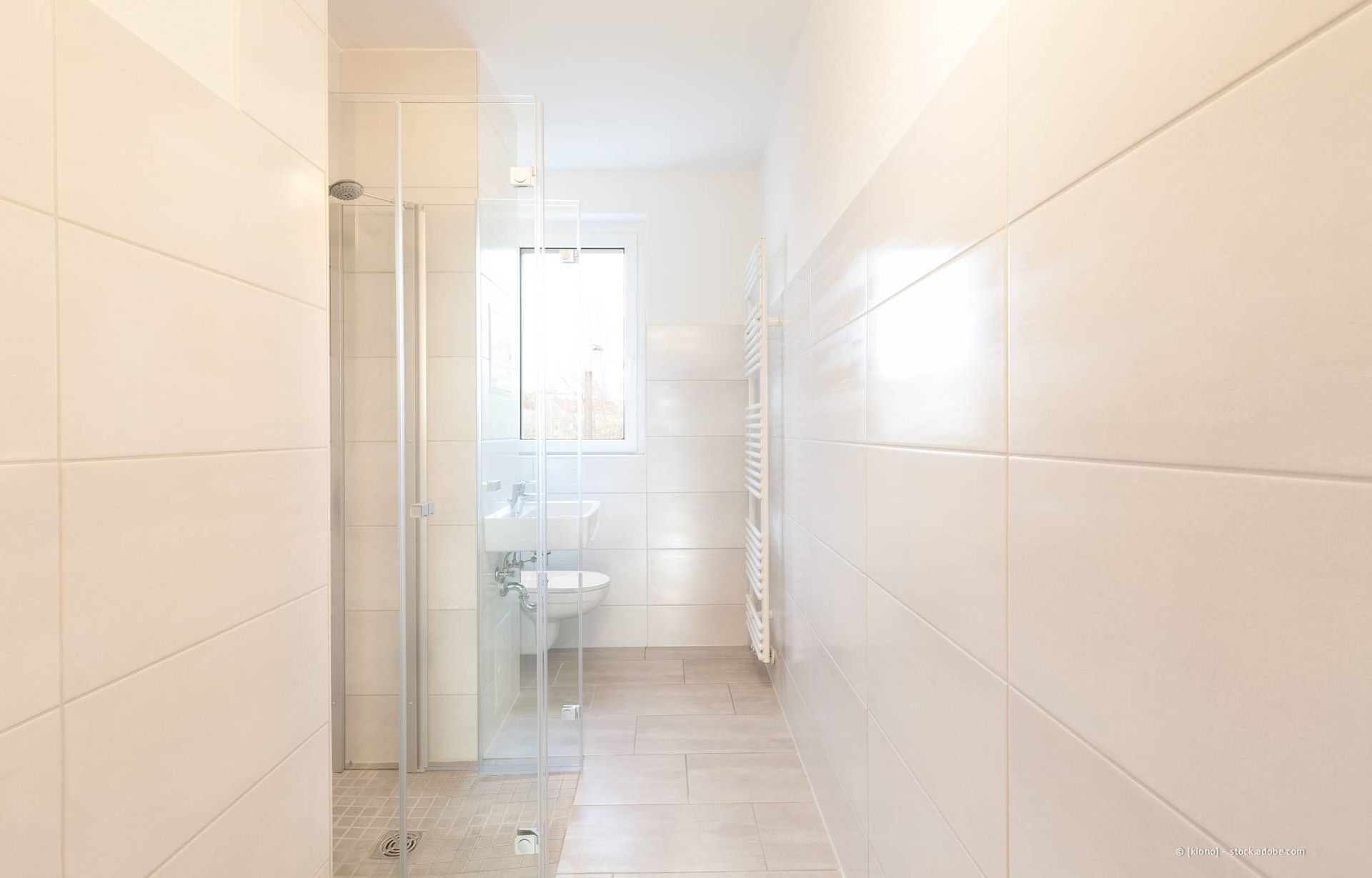 Barrierefreies Badezimmer: Toilette, Waschbecken und Dusche mit Haltegriffen, neutrale Töne, heller, luftiger Raum.