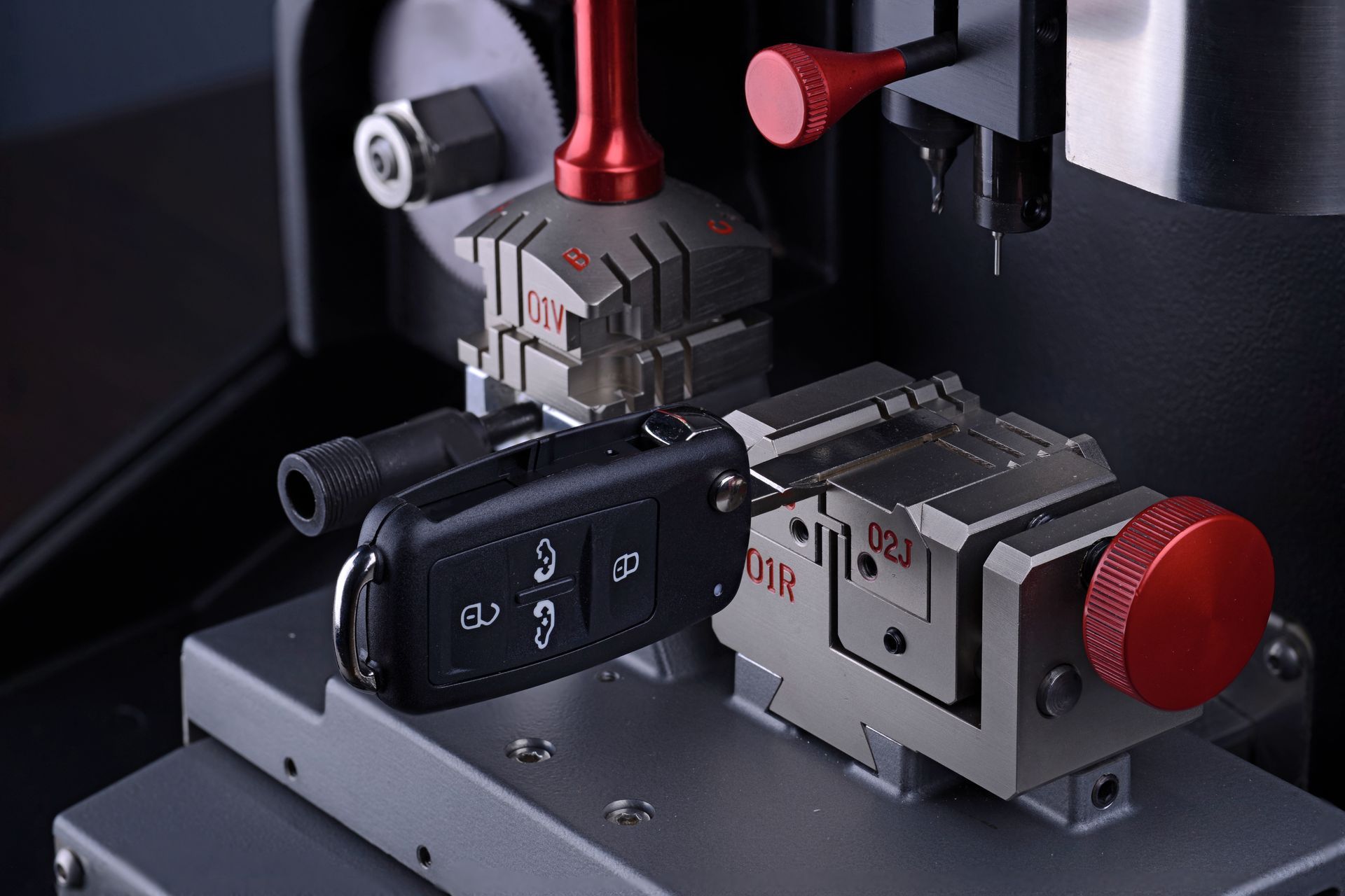 Schlüsselkopiergerät beim Schneiden eines Autoschlüssels. Rote, schwarze und silberne Maschine.