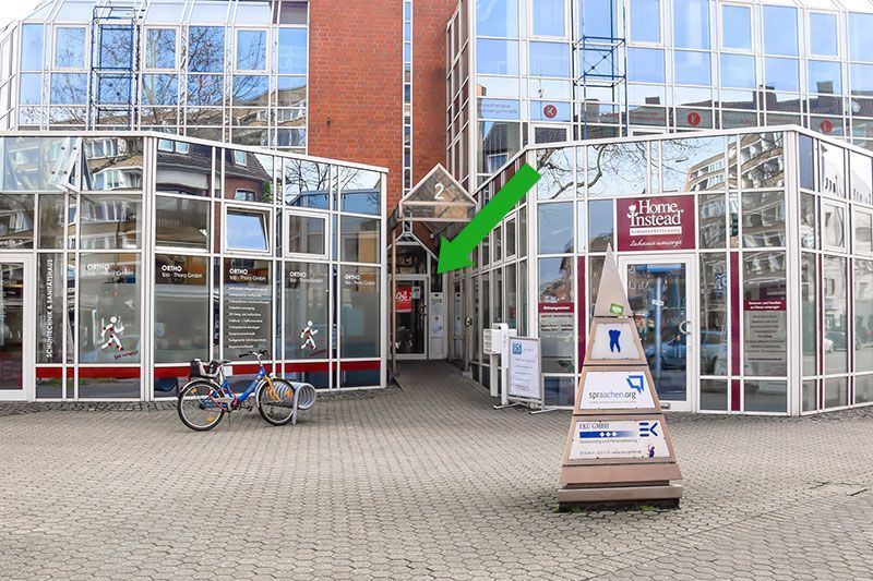 Ein Gebäude mit einem grünen Pfeil, der auf den Eingang zeigt