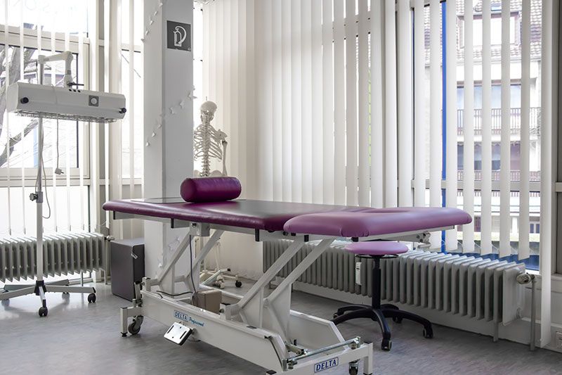 Ein Raum mit einem lila Tisch und einem Skelett im Hintergrund