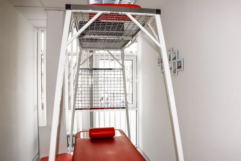 Ein Raum mit einem roten Tisch und einer weißen Leiter