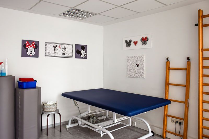 Ein Zimmer mit einem blauen Tisch und Mickey-Mouse-Bildern an der Wand