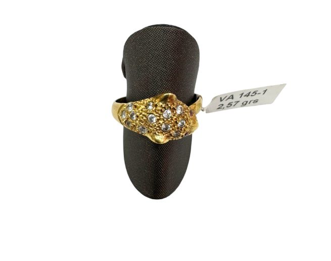 Anillo de oro con piedras transparentes en un expositor negro con etiqueta de precio.