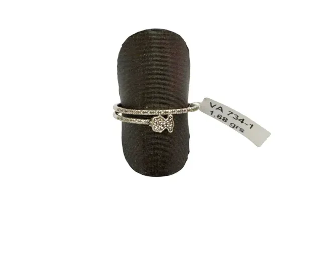 Anillo en expositor negro con etiqueta, que muestra una banda doble con pequeños diamantes y un dije de flor.