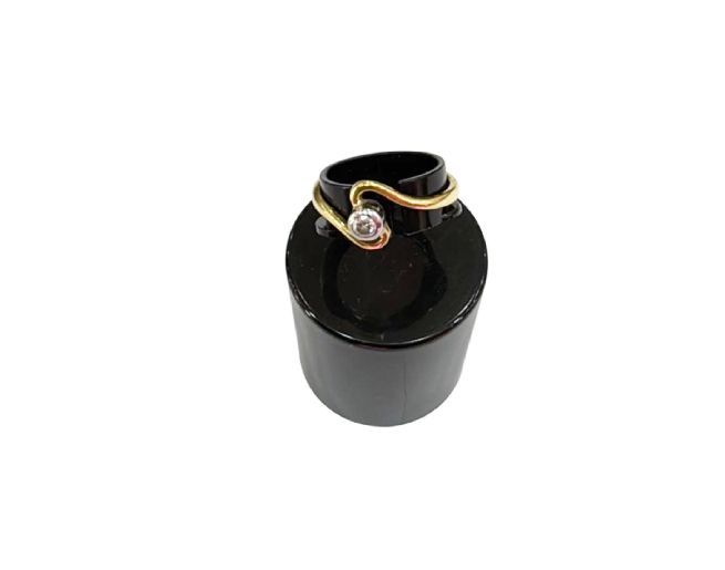 Anillo de oro con un pequeño diamante, expuesto sobre un soporte de anillo negro.