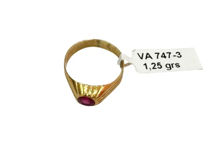 Anillo de oro con una gema roja, etiqueta adjunta que dice