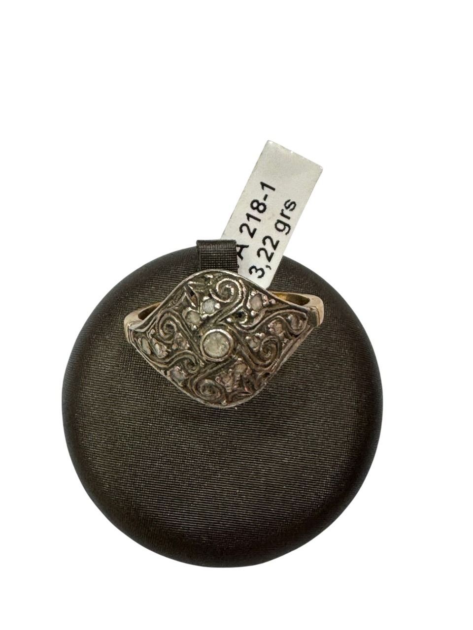 Anillo de oro y diamantes en expositor negro con etiqueta que dice