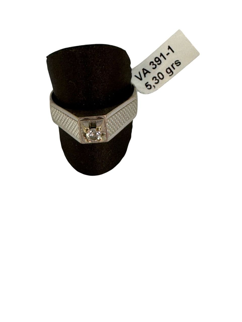 Anillo de plata con un diamante, en expositor negro, con etiqueta de precio.