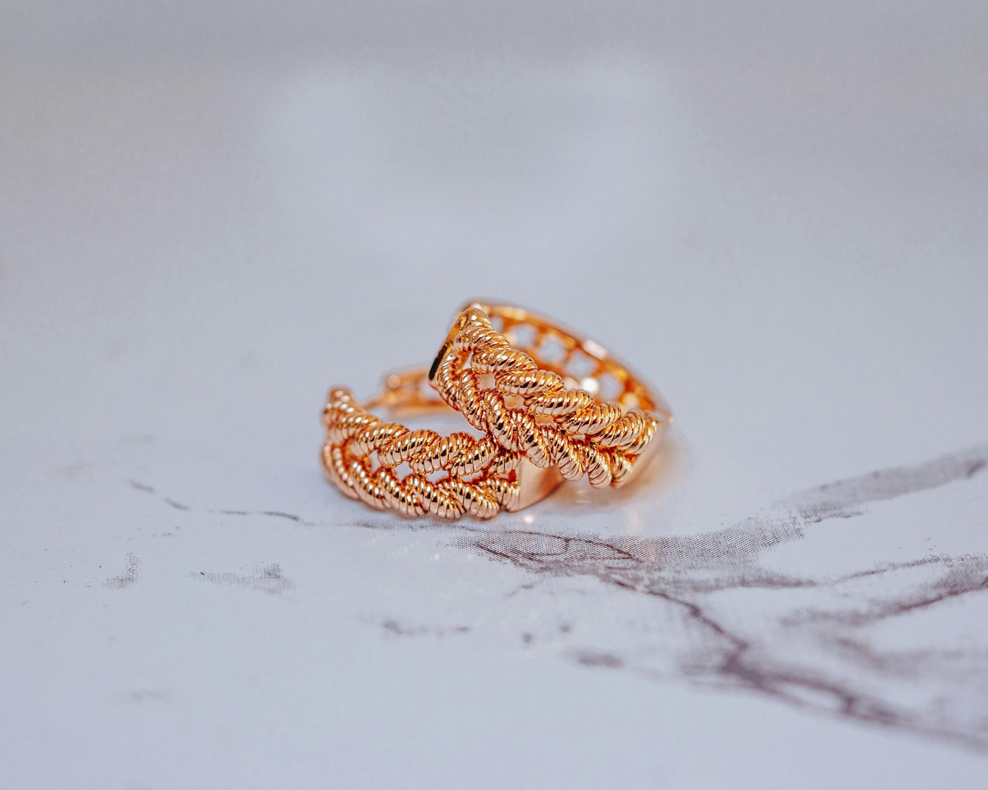 Vitrina de joyería con collares, pulseras y anillos sobre bustos y soportes de maniquí; tonos dorados.