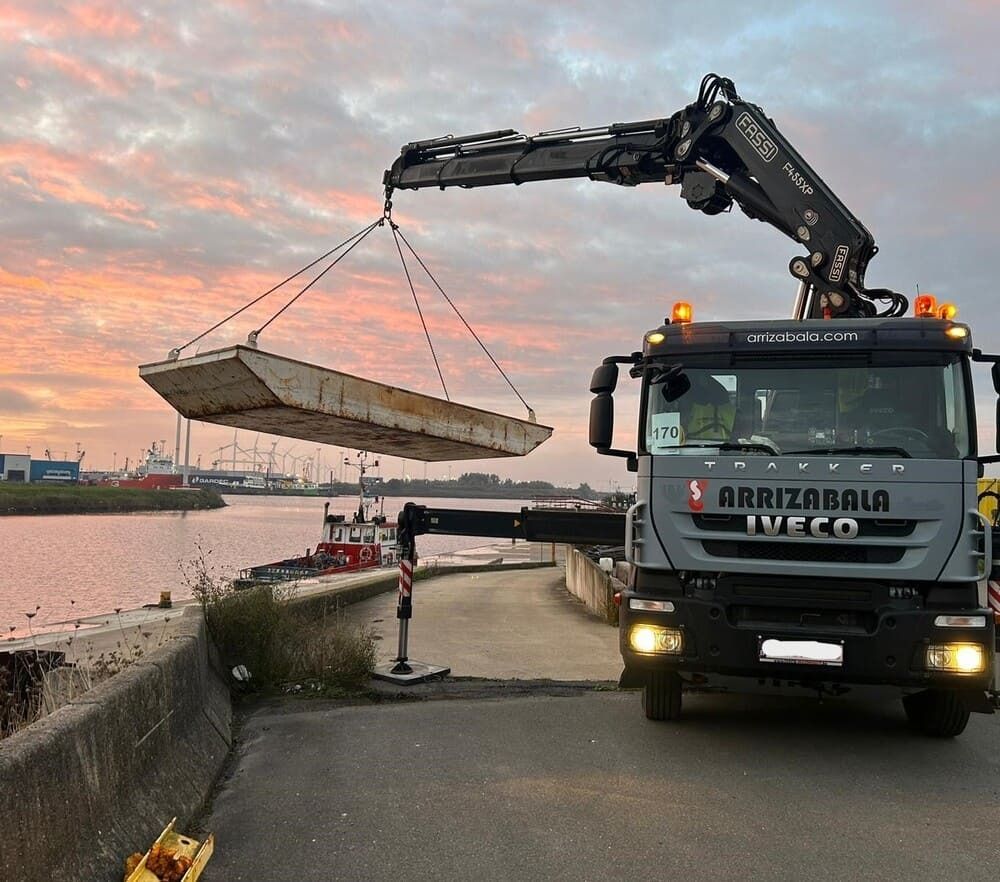 Un camión Iveco está levantando un barco sobre un cuerpo de agua.