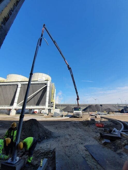 Se está utilizando una grúa para verter hormigón en una obra de construcción.