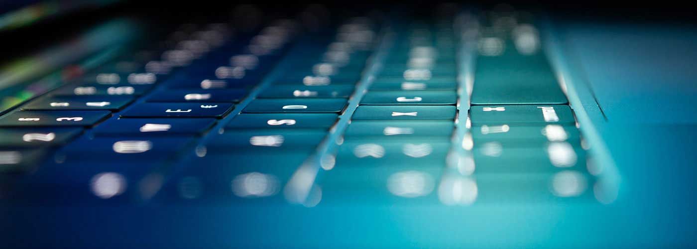 Eine Nahaufnahme einer Laptoptastatur auf einer blauen Oberfläche.