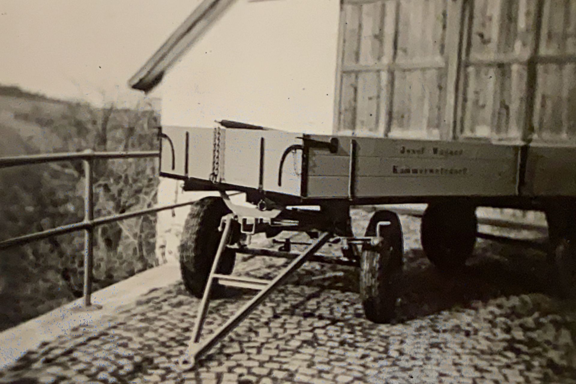 Historischer Gummiwagen vor einer Scheune