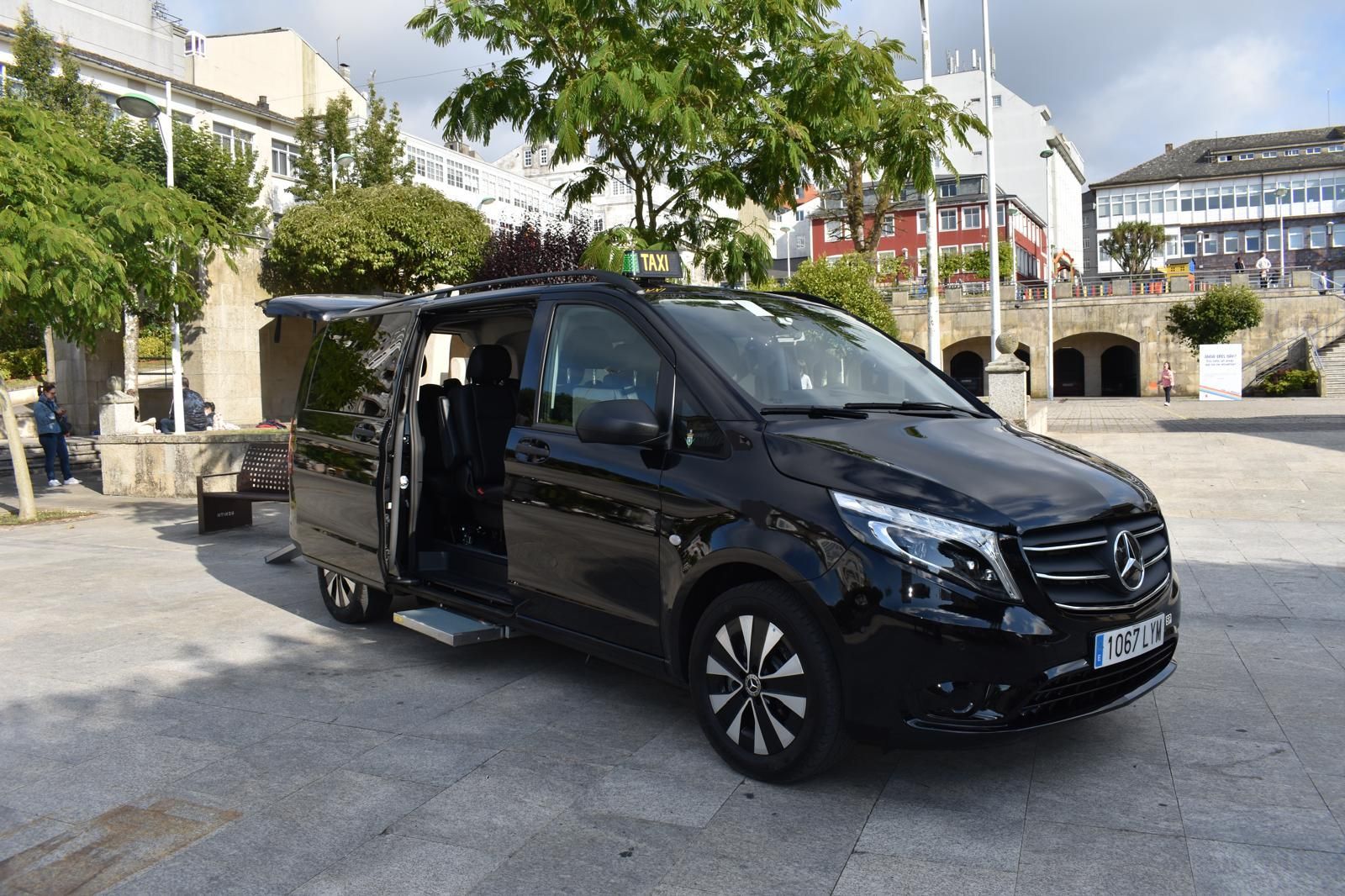 Una camioneta negra está estacionada en un estacionamiento con las puertas abiertas.