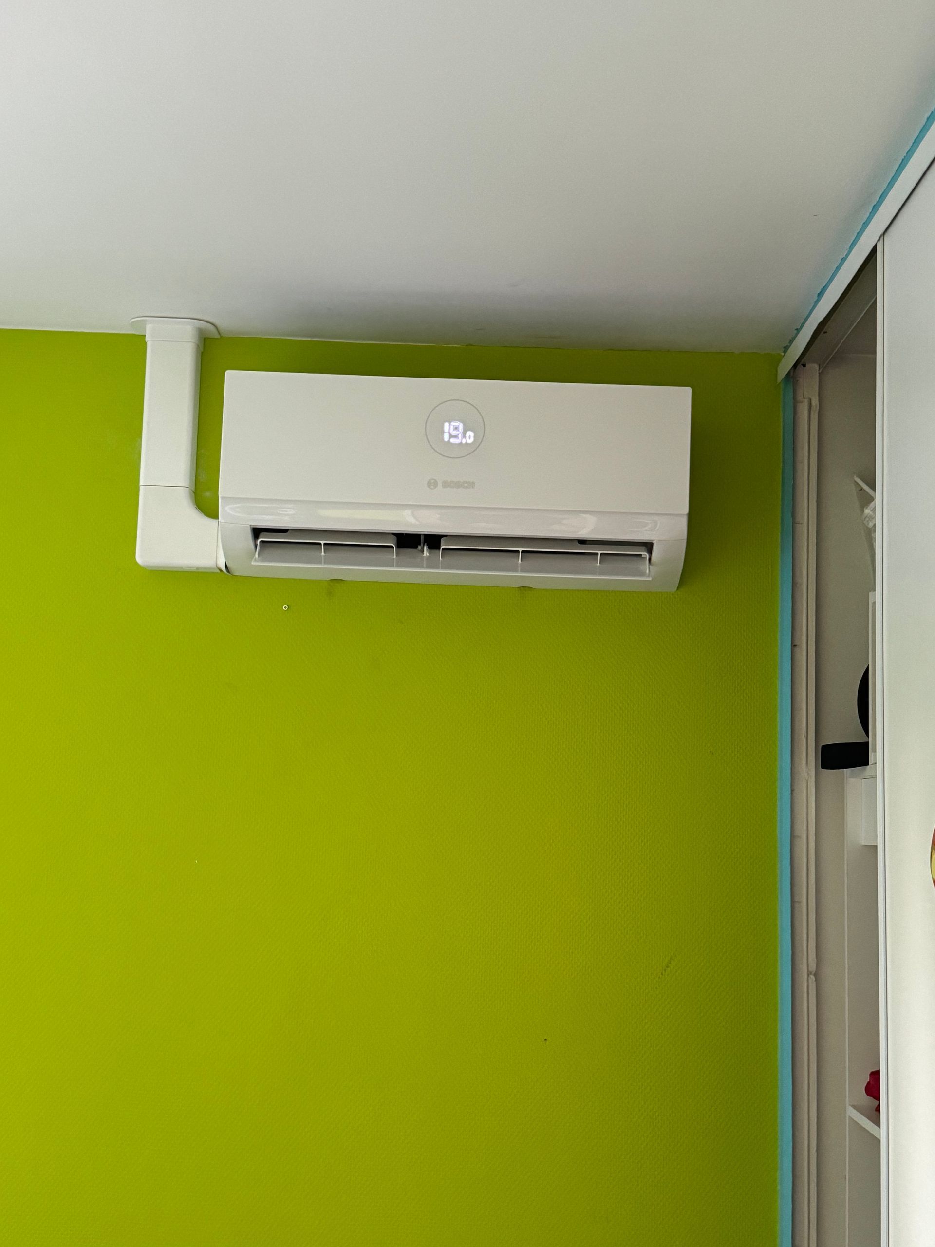 Installation d'une climatisation sur un mur vert