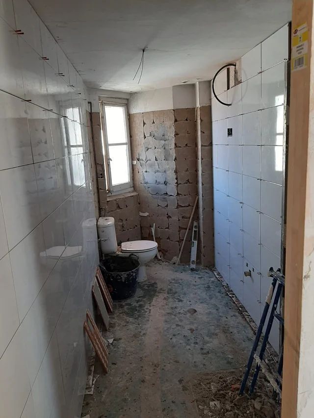 Un baño en construcción con inodoro y ventana.