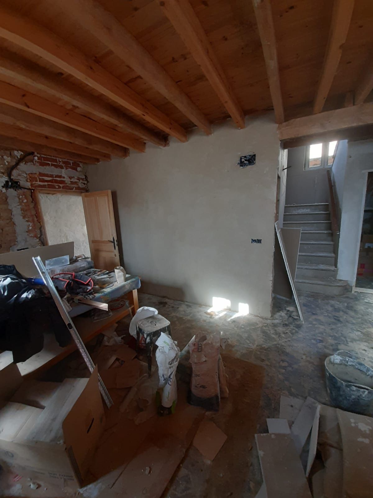 Una habitación con techo de madera y escaleras.