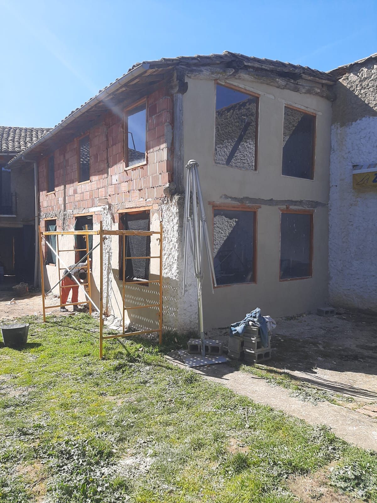 Se está remodelando un edificio de ladrillo con muchas ventanas.